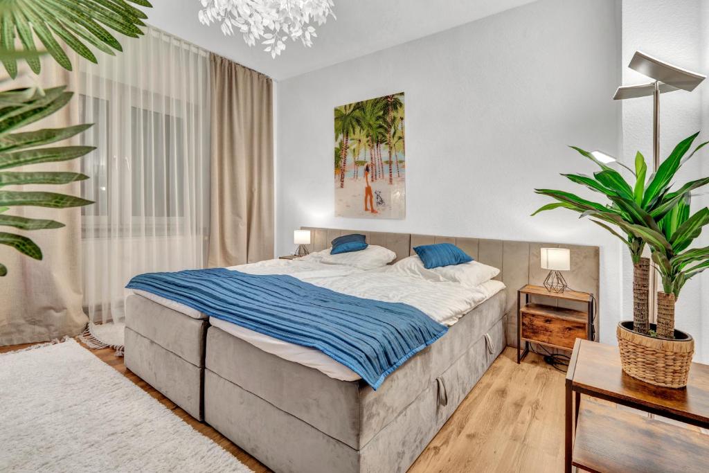 a bedroom with a large bed and a potted plant at JAKSE-Apartments - Urban Jungle - top Lage & flexibler Checkin in Bochum