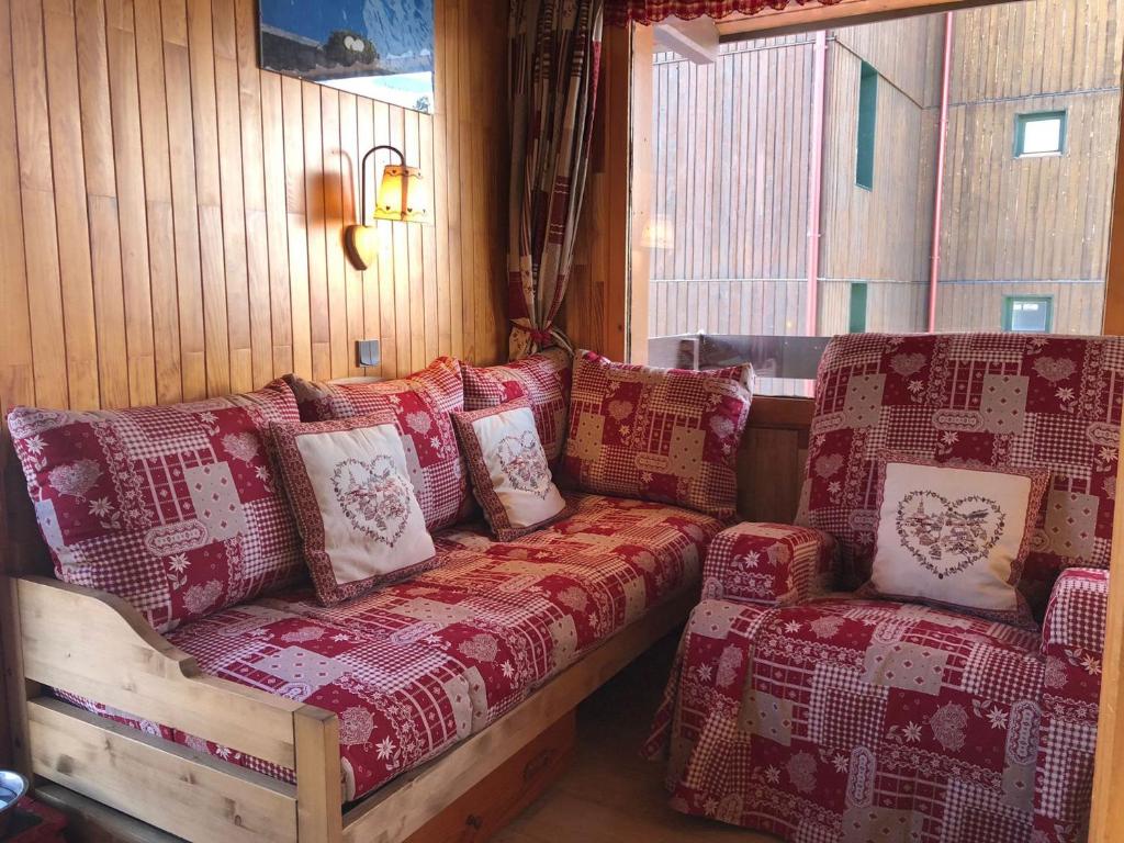 - un canapé avec des oreillers dans l'établissement Appartement chaleureux skis aux pieds x5, balcon, mezza, Belle Plagne - FR-1-181-2180, à La Plagne Tarentaise