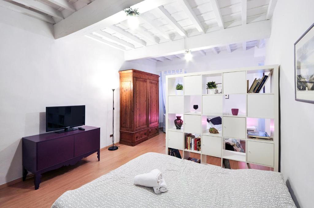 a bedroom with a bed and a tv in a room at Uffizi Apartment in Florence