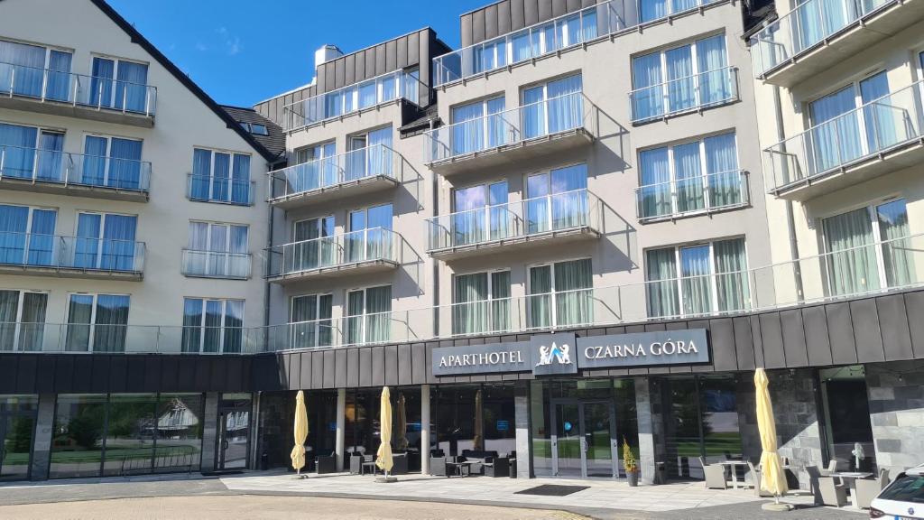 ein Apartmenthaus mit Balkon auf einer Straße in der Unterkunft Aparthotel Apartamenty Czarna Góra 131 in Heudorf