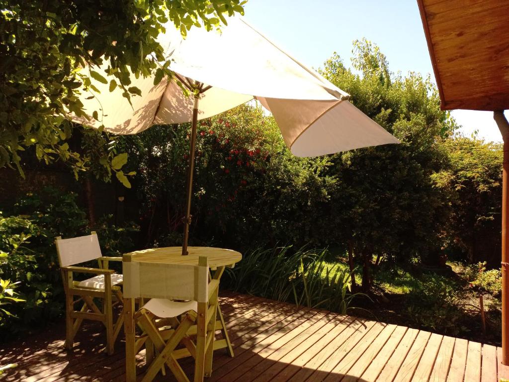 a table and chairs with an umbrella on a patio at Cabañas Donde La Oma in Villarrica