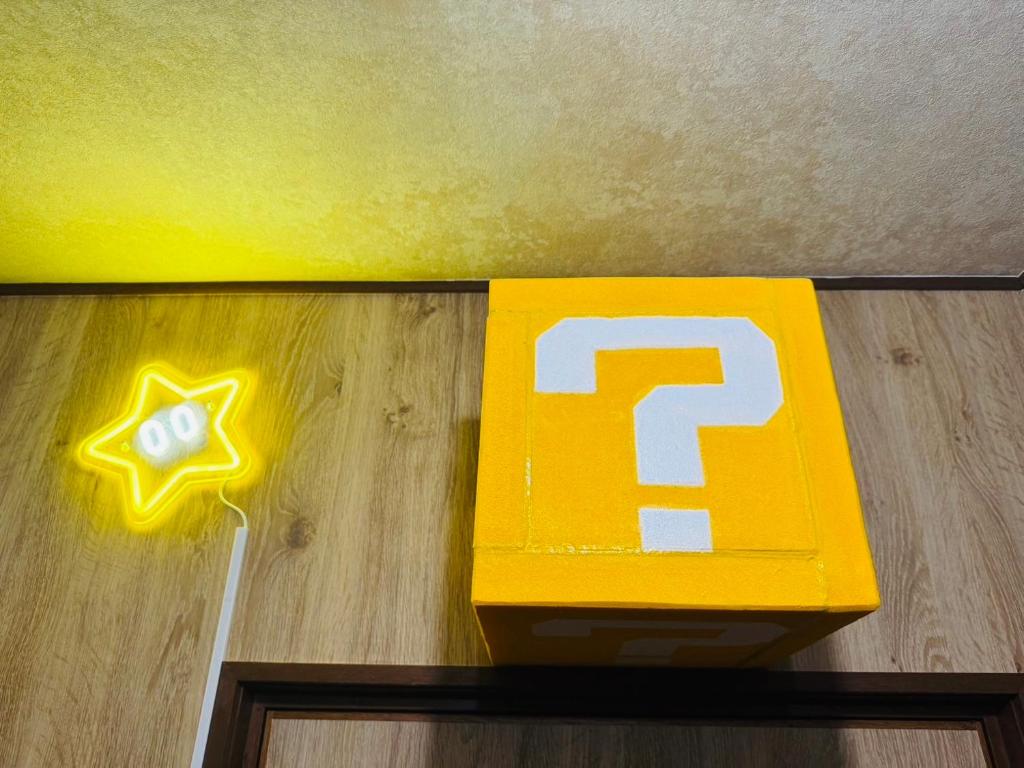 een gele doos met een ster op de vloer bij Hotel Emiru 敷地内駐車場2台 in Osaka