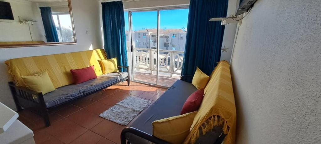 Una sala de estar con un sofá y una ventana con vistas. en Unit 75 Hermanus Beach Club, en Hermanus