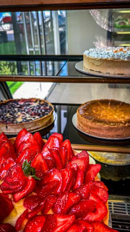 a display case with different types of cakes and pies at Ecohotel Talca in Talca