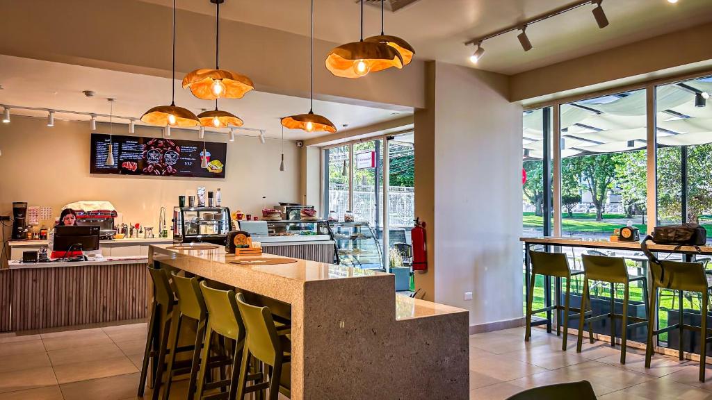 a restaurant with a bar with yellow bar stools at Ecohotel Talca in Talca