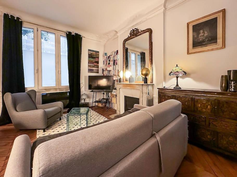 un salon avec un canapé et un miroir dans l'établissement Montmartre with private courtyard, à Paris