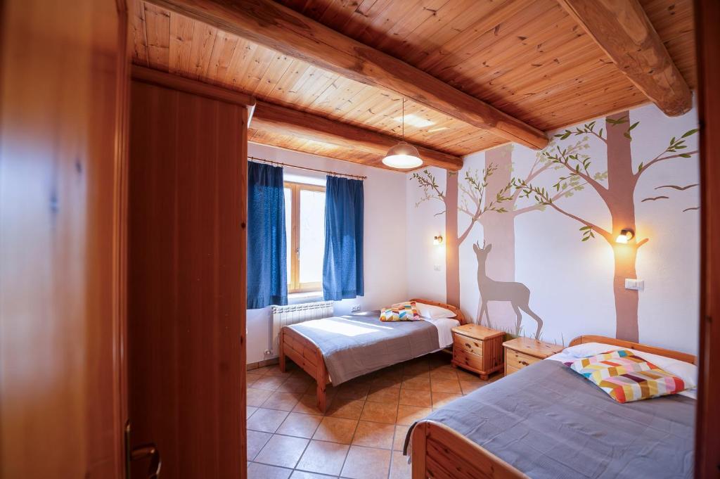 sypialnia z 2 łóżkami i malowidłem drzewnym na ścianie w obiekcie Agriturismo Fattoria Walden w mieście Ficulle