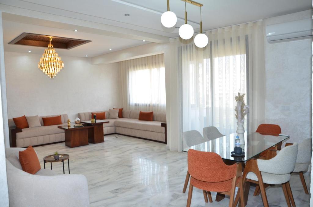 un soggiorno con un divano, un tavolo e delle sedie di Miramar Prestigia a Ville Nouvelle