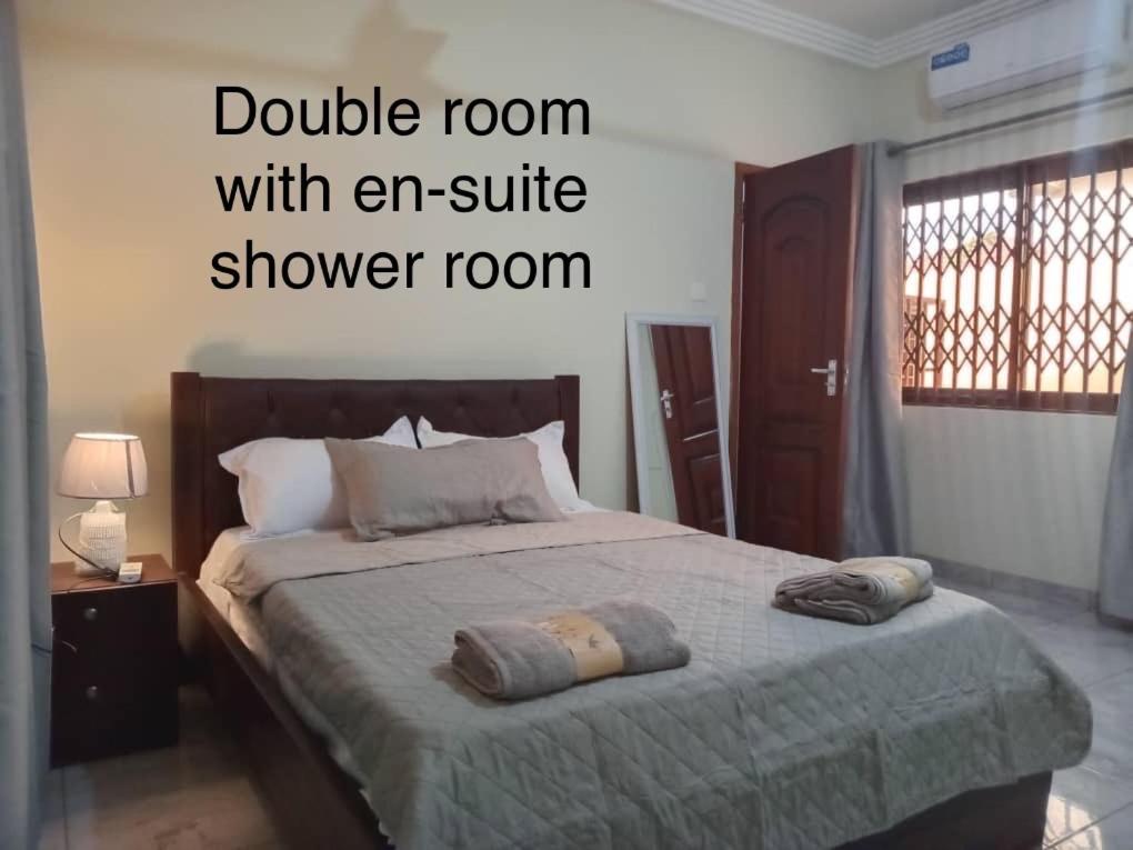 una camera da letto con un letto e un intero bagno con doccia di Dawhenya Bungalow 2 a Tema