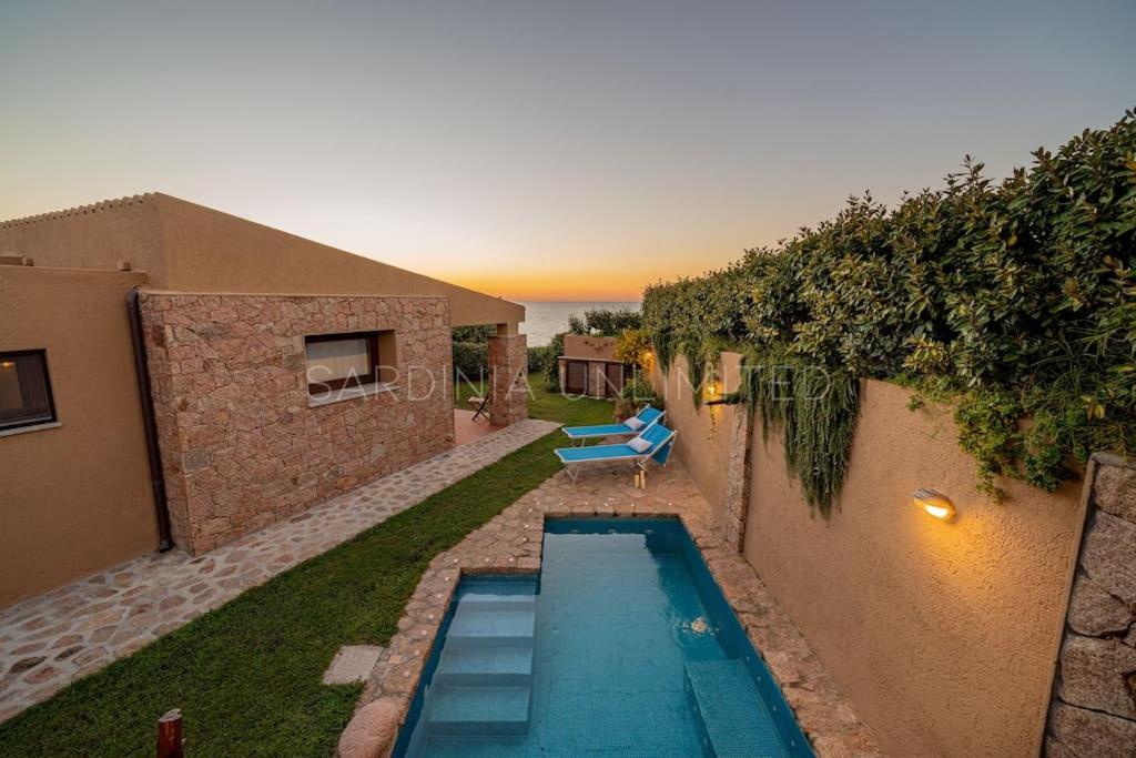 a swimming pool in the backyard of a house at Villa Lumière in Costa Paradiso