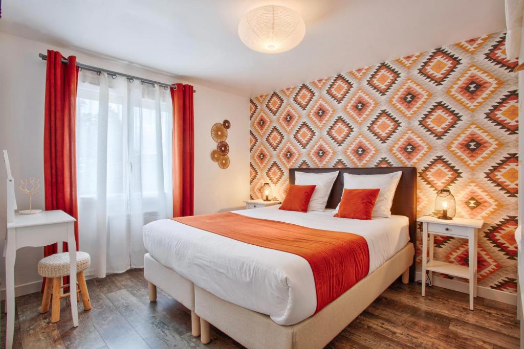 een slaapkamer met een groot bed met rode gordijnen bij Les Bicoques à la mer - "Un air de Bicoque" in Dives-sur-Mer