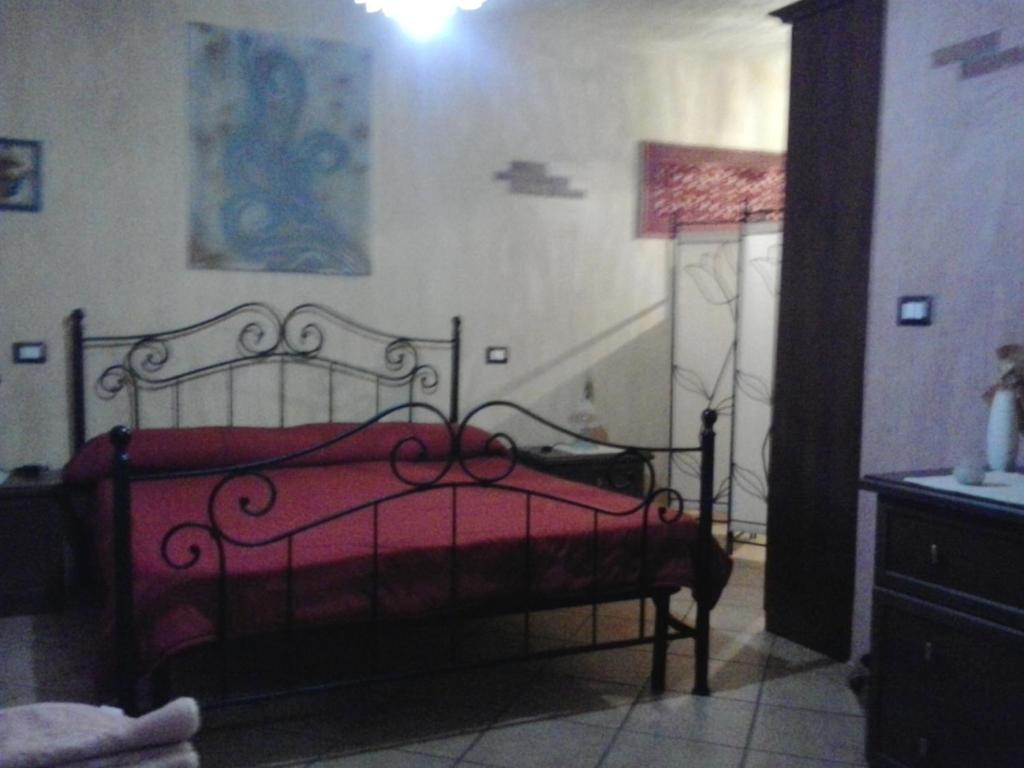 um quarto com uma cama com um cobertor vermelho em Casa Signorile em Càbras