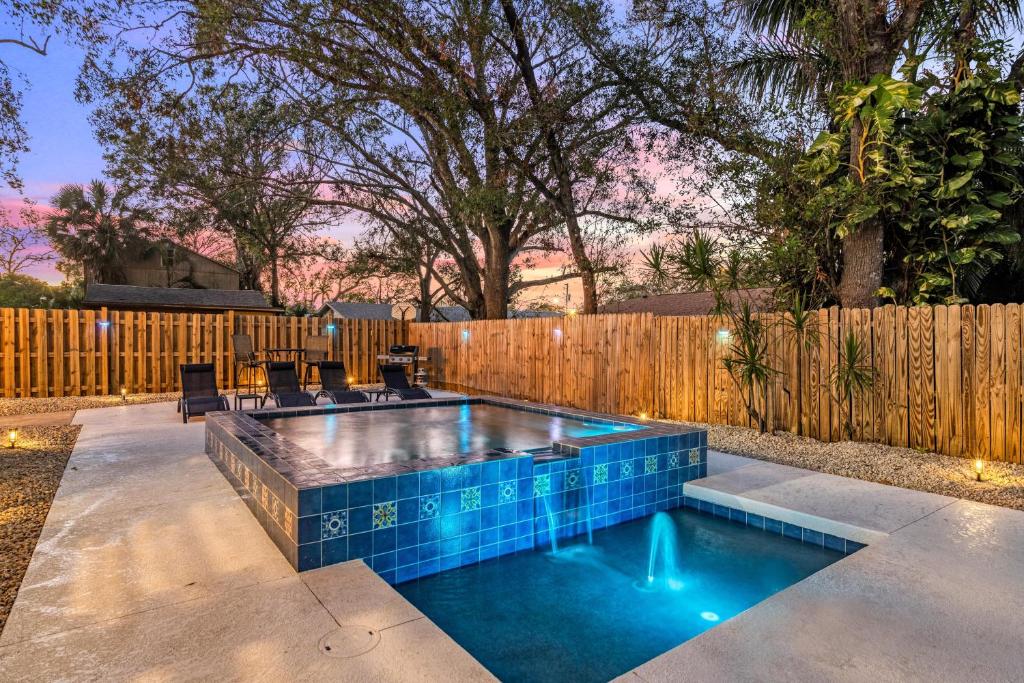 een zwembad in een achtertuin met een houten hek bij Step into the charm of yesteryear with the modern comforts of today at City Cottage! in Sarasota