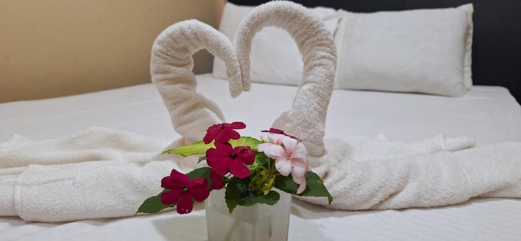 a hotel room with towels and a vase with flowers at Villa Cinnamon Homestay in Diyatalawa
