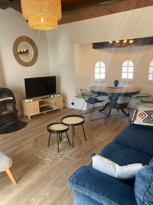 un salon avec un canapé bleu et une table dans l'établissement Maison située à 150m de la plage de la Madeleine, à Noirmoutier-en-l'lle