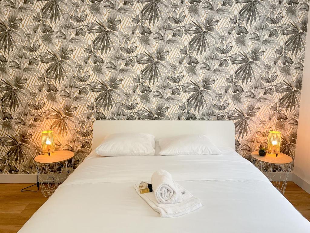 - une chambre avec un lit et du papier peint en palmier dans l'établissement Le Masséna - Lyon 6ème - Proche Parc Tête d'Or, à Lyon