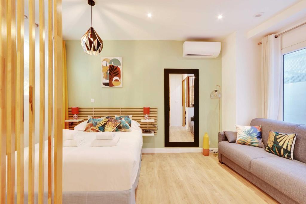 un salon avec un grand lit et un canapé dans l'établissement Charming apartment with AC -1BR-3P- Sentier, à Paris