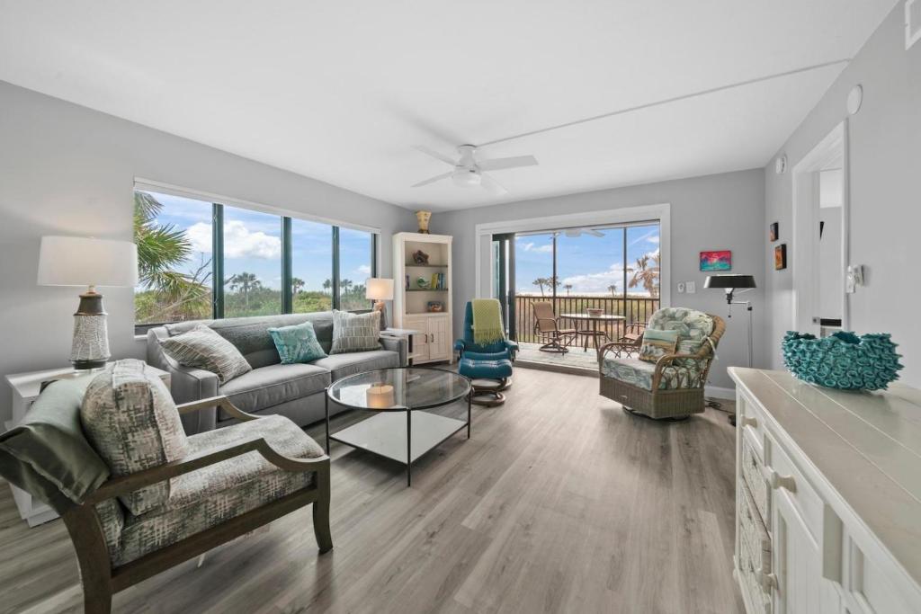 a living room with a couch and chairs and a table at Sandpiper Beach 101 in Sanibel