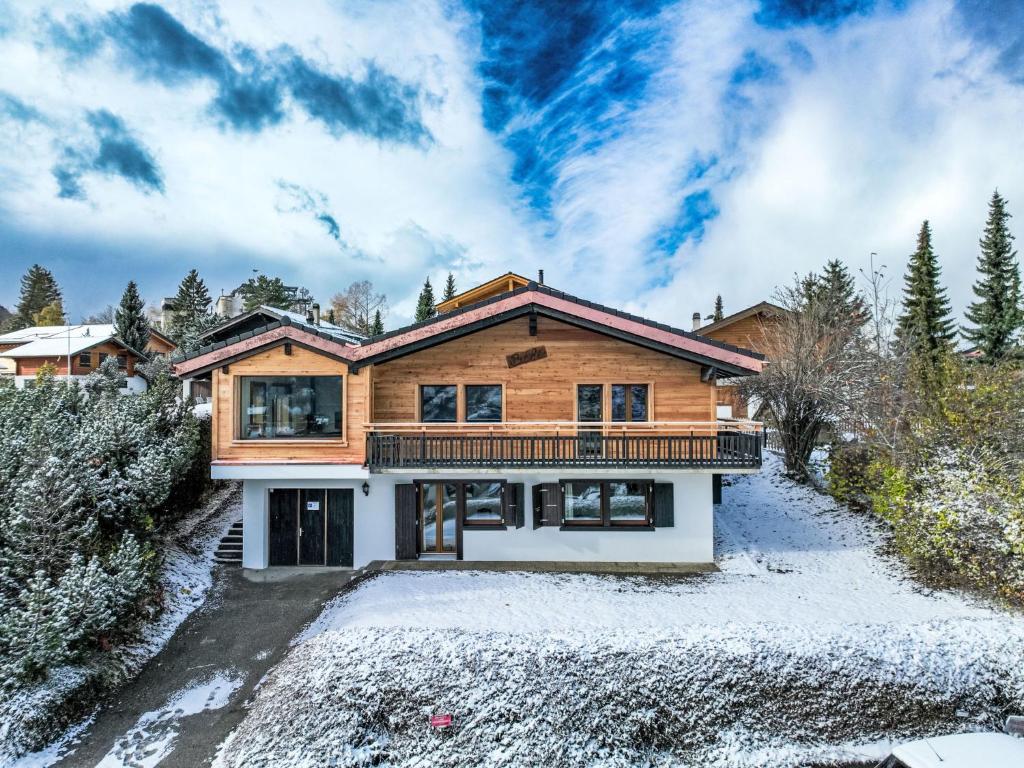 a log home with a deck in the snow at Chalet Beke by Interhome in Nendaz
