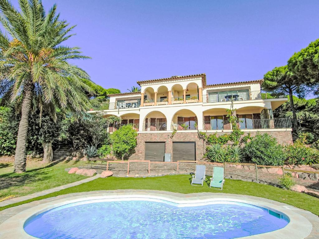 a large house with a swimming pool in front of it at Holiday Home Puig Romani-2 by Interhome in Platja  d'Aro
