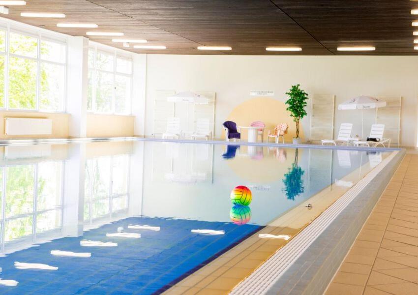 a large swimming pool with a person in the water at Apartment Morgengruß - Pool & Sauna in Hohegeiß