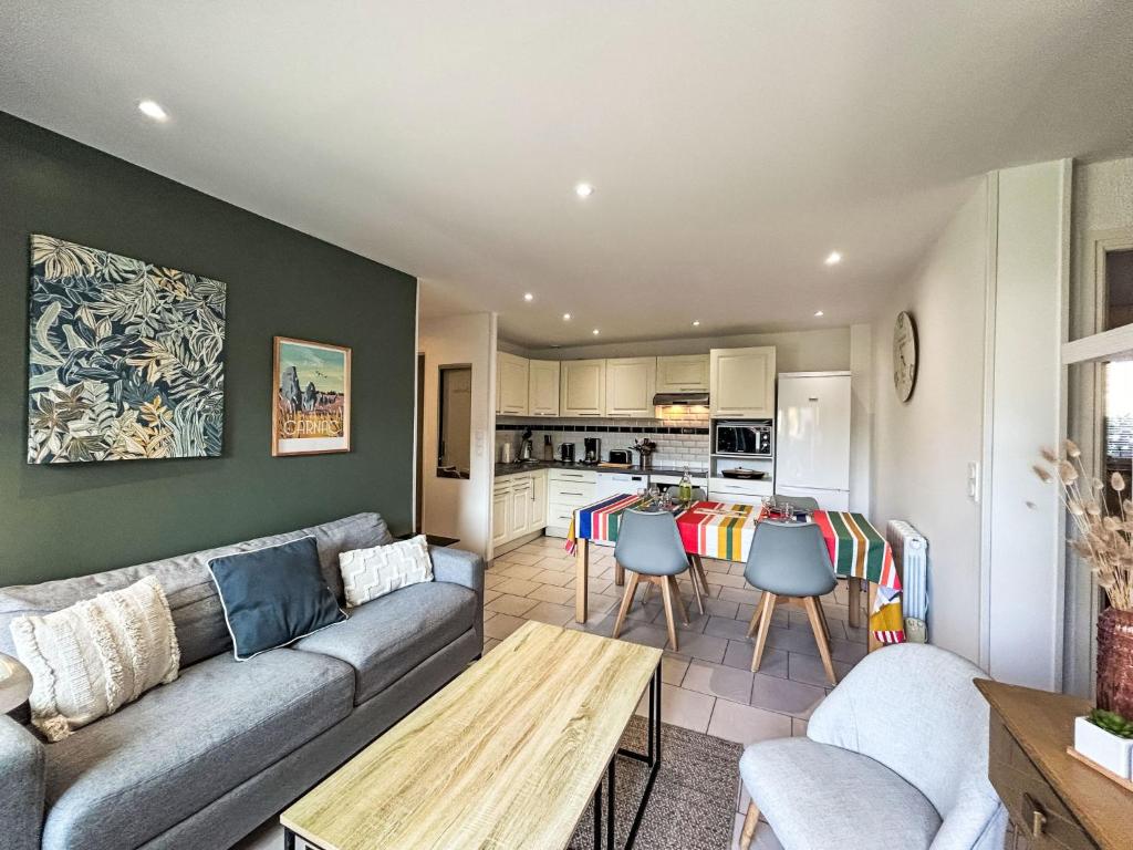 a living room with a couch and a kitchen at Apartment Les Alizés-1 by Interhome in Carnac-Plage