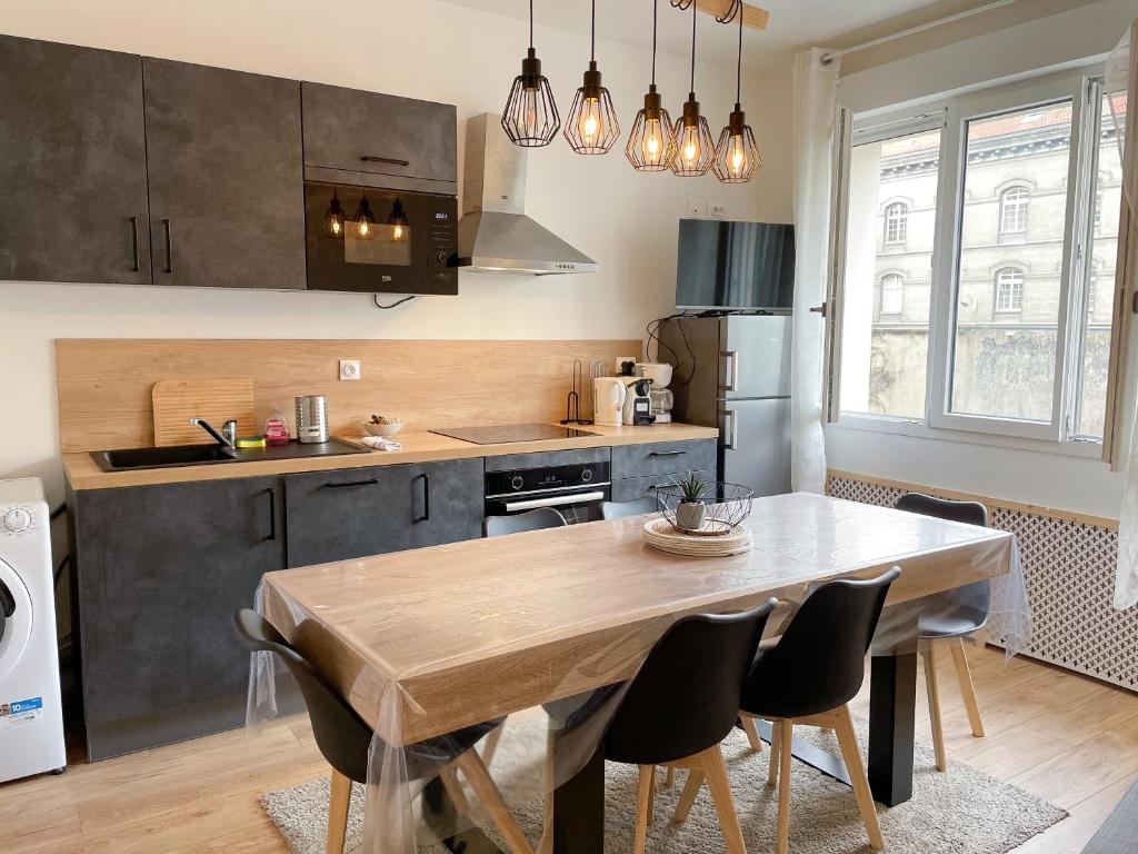 une cuisine avec une table en bois et une salle à manger dans l'établissement Le Cour Vitton - Lyon 6ème - Proche Parc Tête d'Or, à Lyon