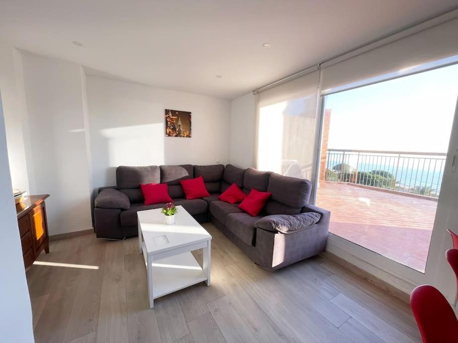 a living room with a couch and a table at Ático con terraza en La Pineda in La Pineda