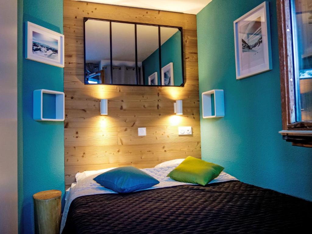 a bedroom with a bed with a mirror on the wall at Apartment Nazca I6 by Interhome in Val Thorens