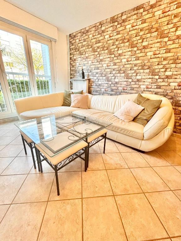 un salon avec un canapé et un mur de briques dans l'établissement Le bijou d'Ivelina - 3 chambres - wifi - parking, à Chartres
