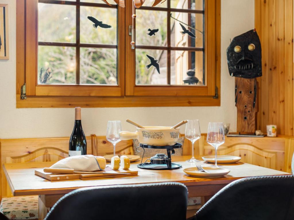 a table with two wine glasses and aookyooky at Holiday Home Lätthaus Rot by Interhome in Täsch