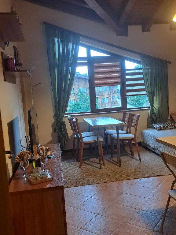 a living room with a table and chairs at Pirin Golf hotel, Apartment Chalet style in Razlog