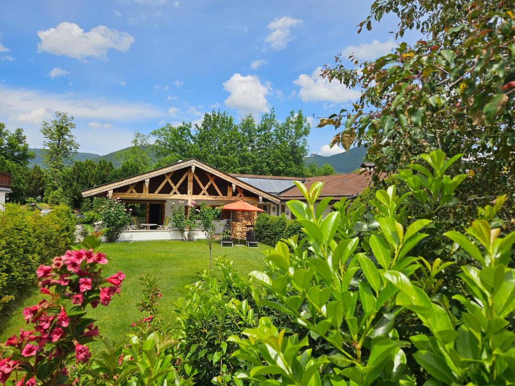a house with a green yard with flowers at Ferienhaus Gottschlicht Bei Rottach Egern Am Tegernsee, Eigener Parkplatz, W Lan in Rottach-Egern
