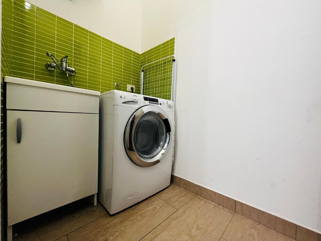 a washer and dryer in a bathroom with green tile at Le Dimore del Corso in Catania