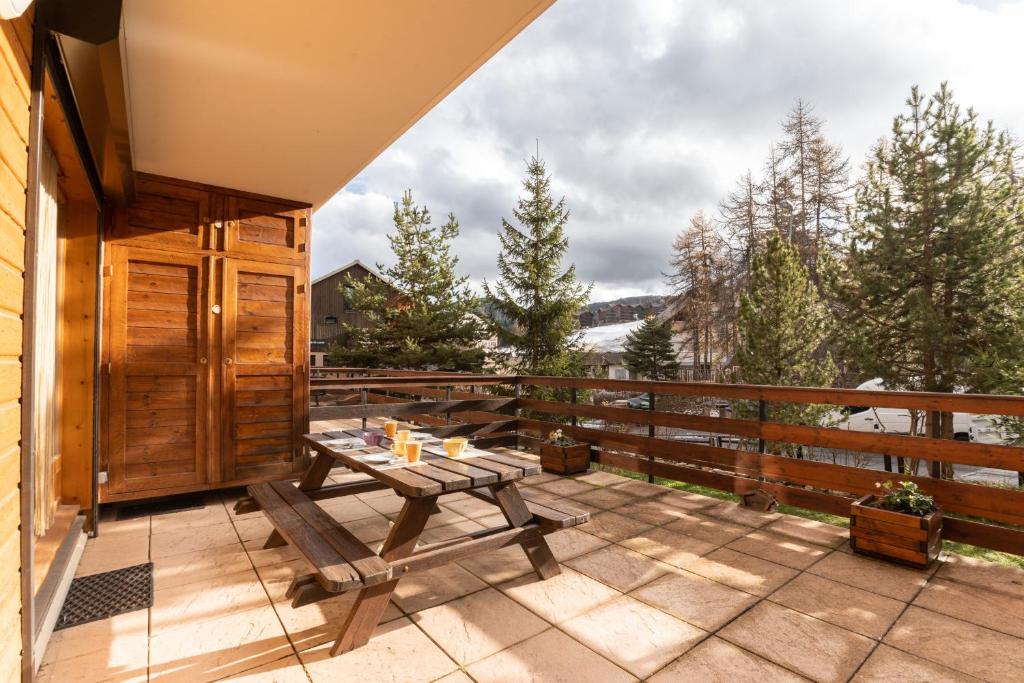 d'une terrasse avec une table et des bancs sur un balcon. dans l'établissement La Joue du Loup, appartement pour 4 avec terrasse, à Saint-Étienne-en-Dévoluy