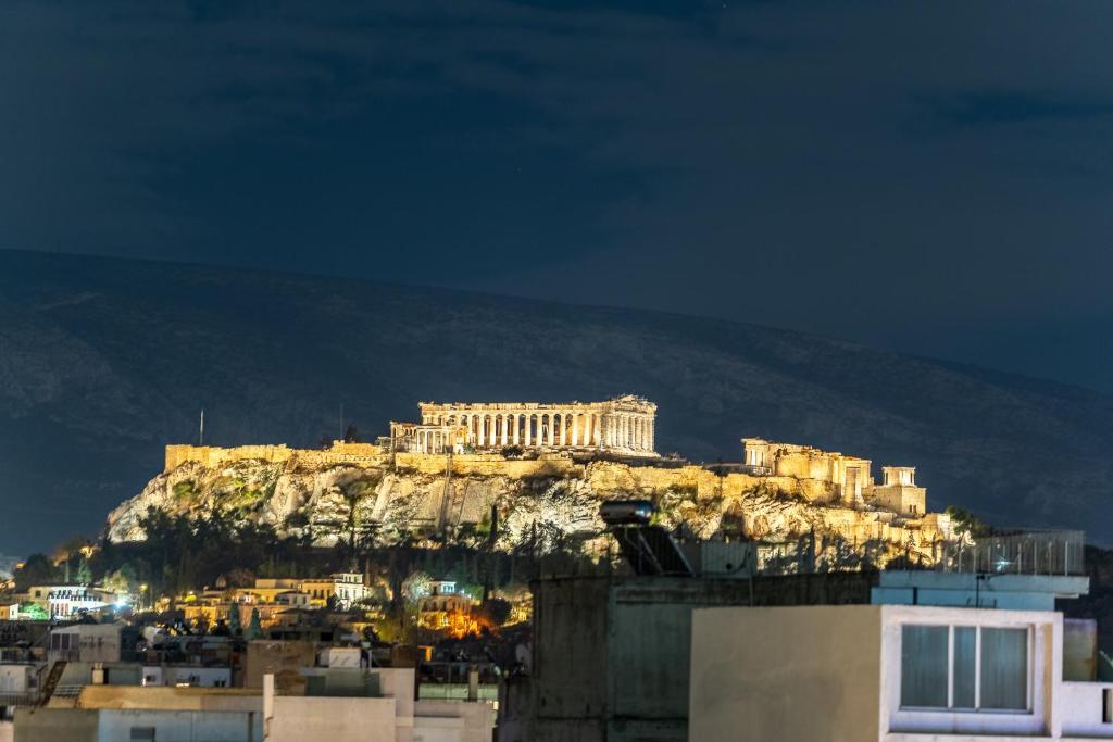 ein Gebäude auf einem Berg in der Nacht in der Unterkunft Acropolis Luxury Apartment with Balcony in Athen
