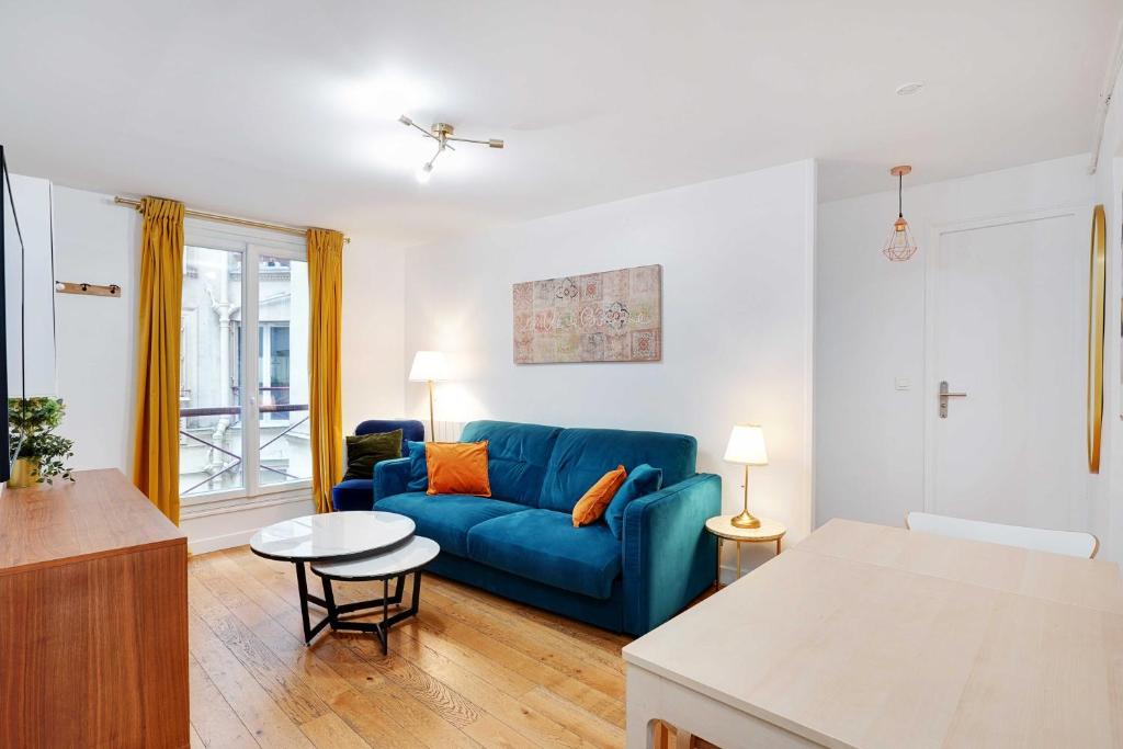 un salon avec un canapé bleu et une table dans l'établissement Confort et Charme pour 6 à Republioque, à Paris
