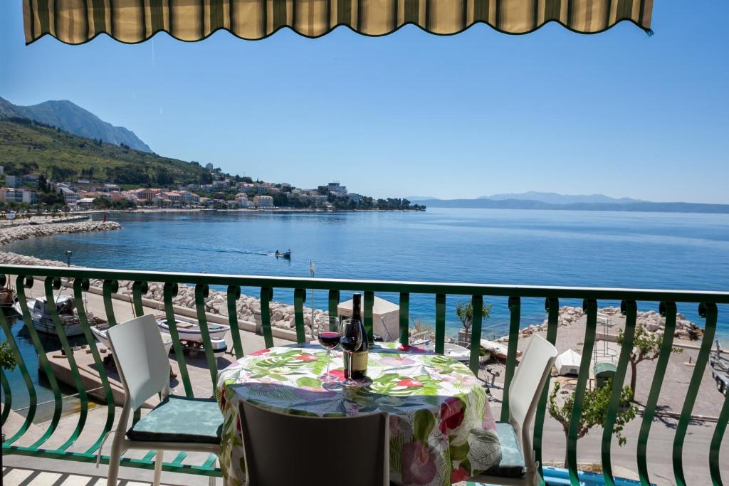 una mesa en un balcón con vistas al océano en Apartments Waterfront Ivan, en Podgora