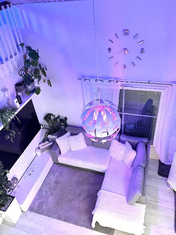 a living room with a purple couch and a clock at Hopea Villa in Vuokatti
