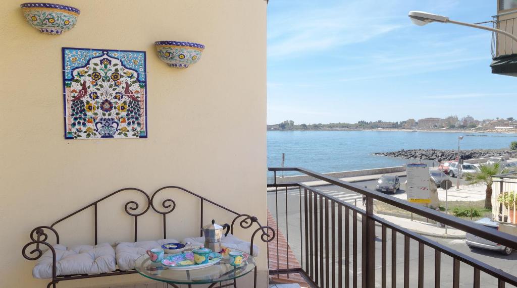 a balcony with a table and a view of the water at Apartment Tysandros in Giardini Naxos