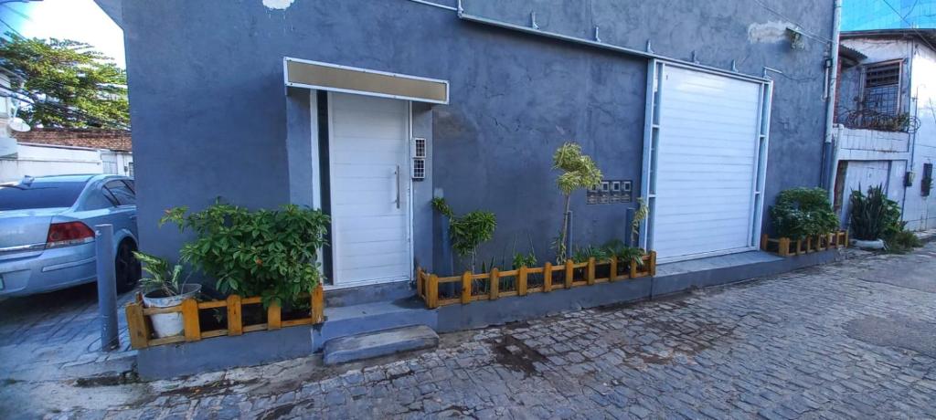 a blue building with a white door and some plants at Loft Portal Beach 01 in Recife