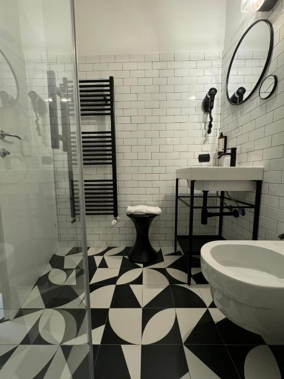 a bathroom with a black and white checkered floor at Re Versiliana Hotel in Marina di Pietrasanta