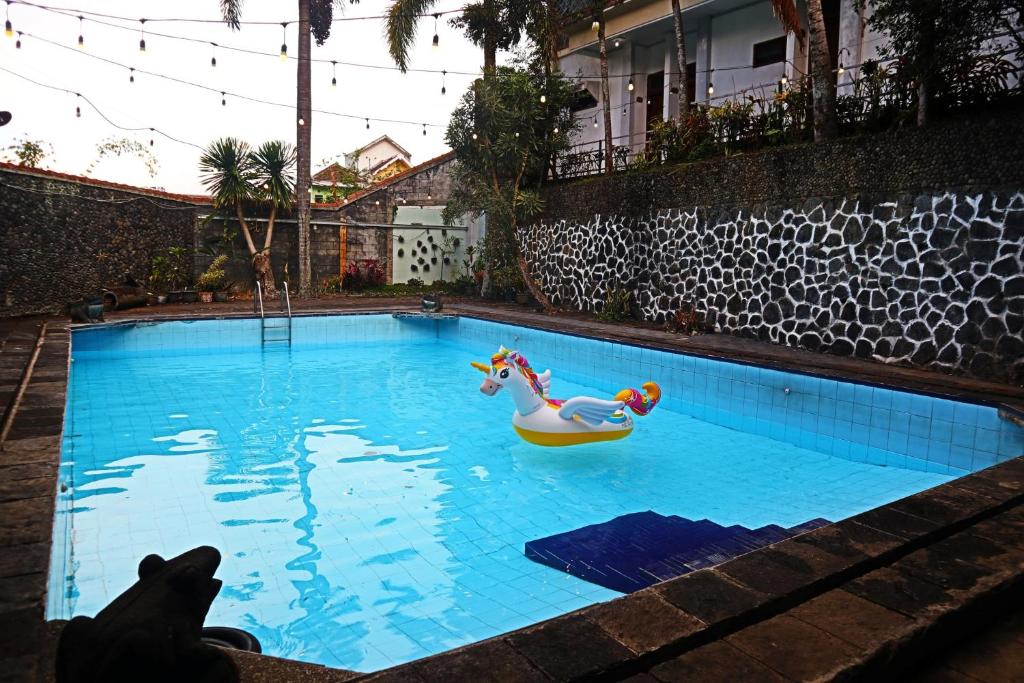 a swimming pool with a toy horse and a float at PLUM Hotel Palereman Batu in Batu