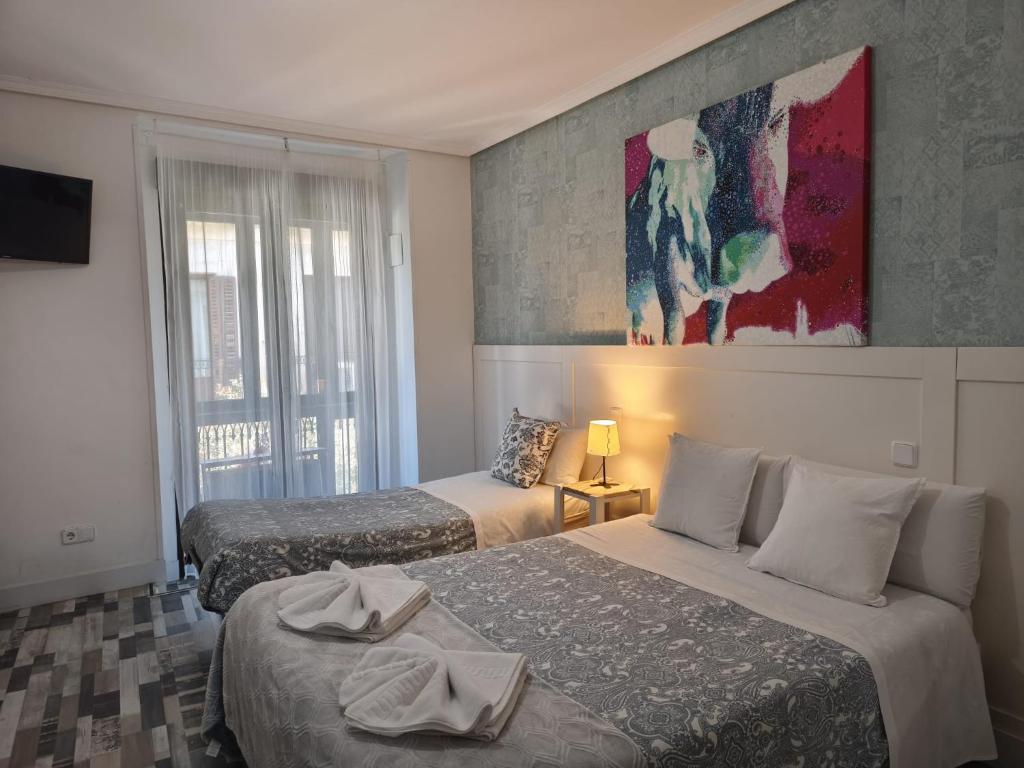 Una habitación de hotel con dos camas y un cuadro en la pared. en Fuencarral Adeco, en Madrid