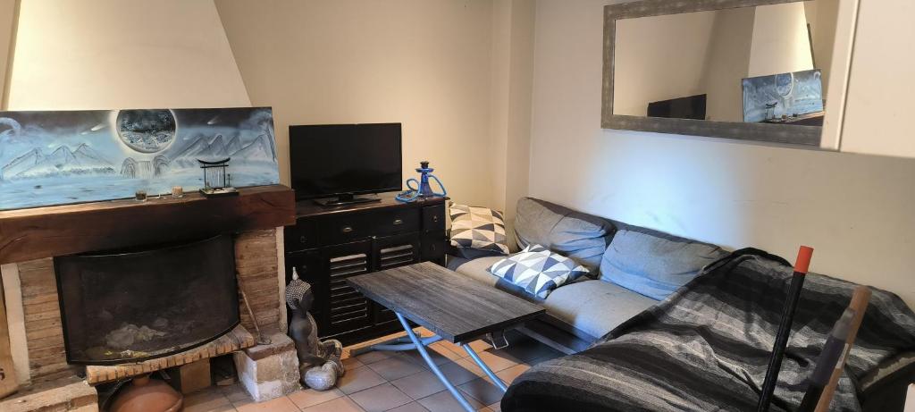 un salon avec un canapé et une cheminée dans l'établissement maison de village, à La Valette-du-Var