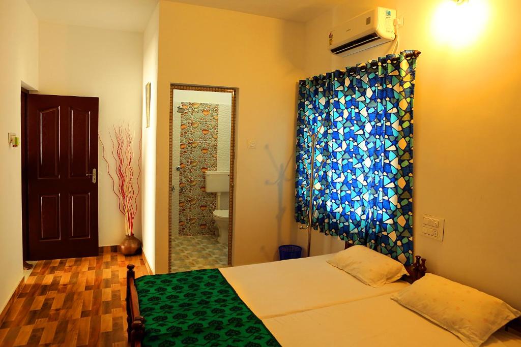 a bedroom with a bed and a shower at Heather Home Stay in Cochin