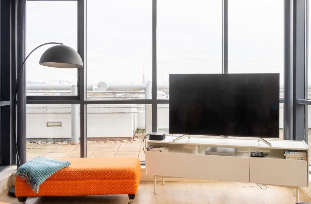 a living room with a tv and a large window at GuestReady - Enchanting views from Millenium Tower in Dublin