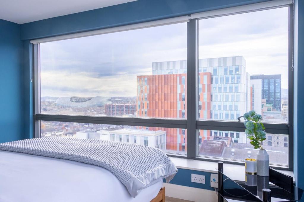 a bedroom with a large window with a view of a city at GuestReady - Enchanting views from Millenium Tower in Dublin