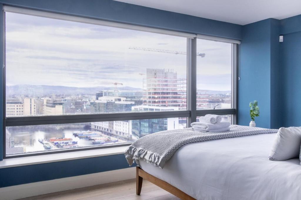 a bedroom with a large window with a view of a city at GuestReady - Enchanting views from Millenium Tower in Dublin