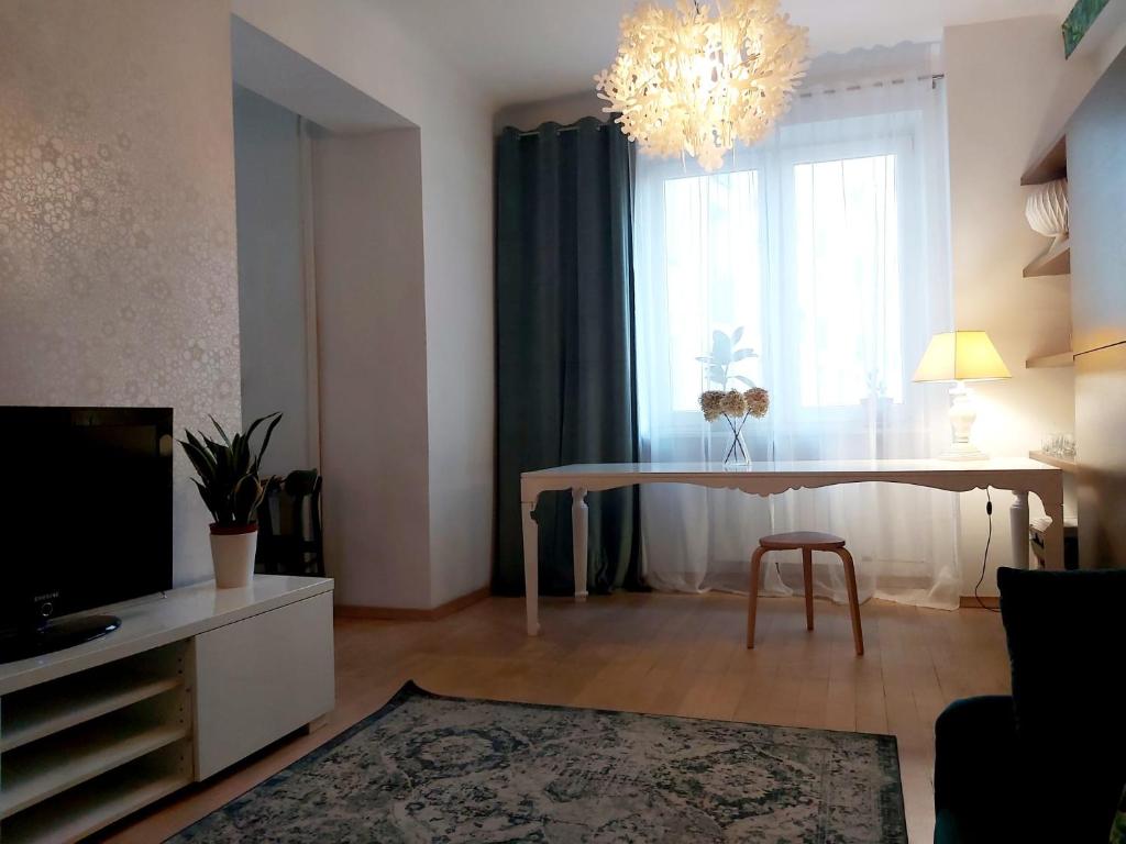 Televízia a/alebo spoločenská miestnosť v ubytovaní Apartament Koszykowa 1
